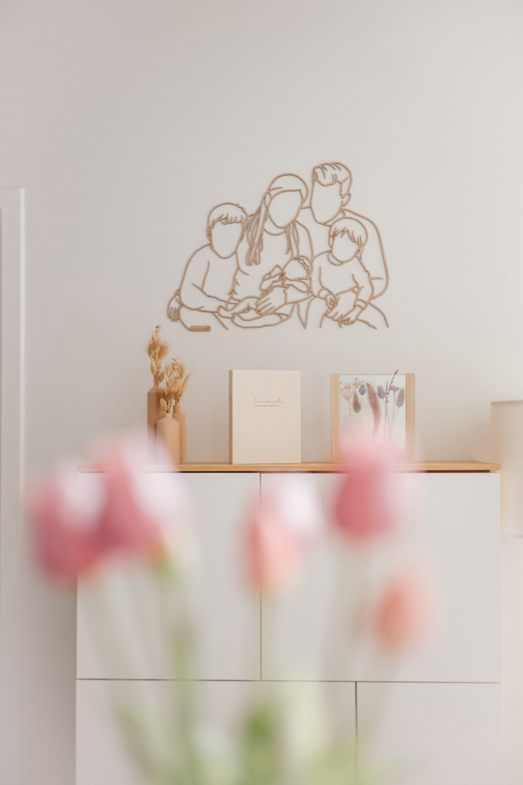 Portrait linéaire en bois d’une jeune famille avec bébé au-dessus du meuble